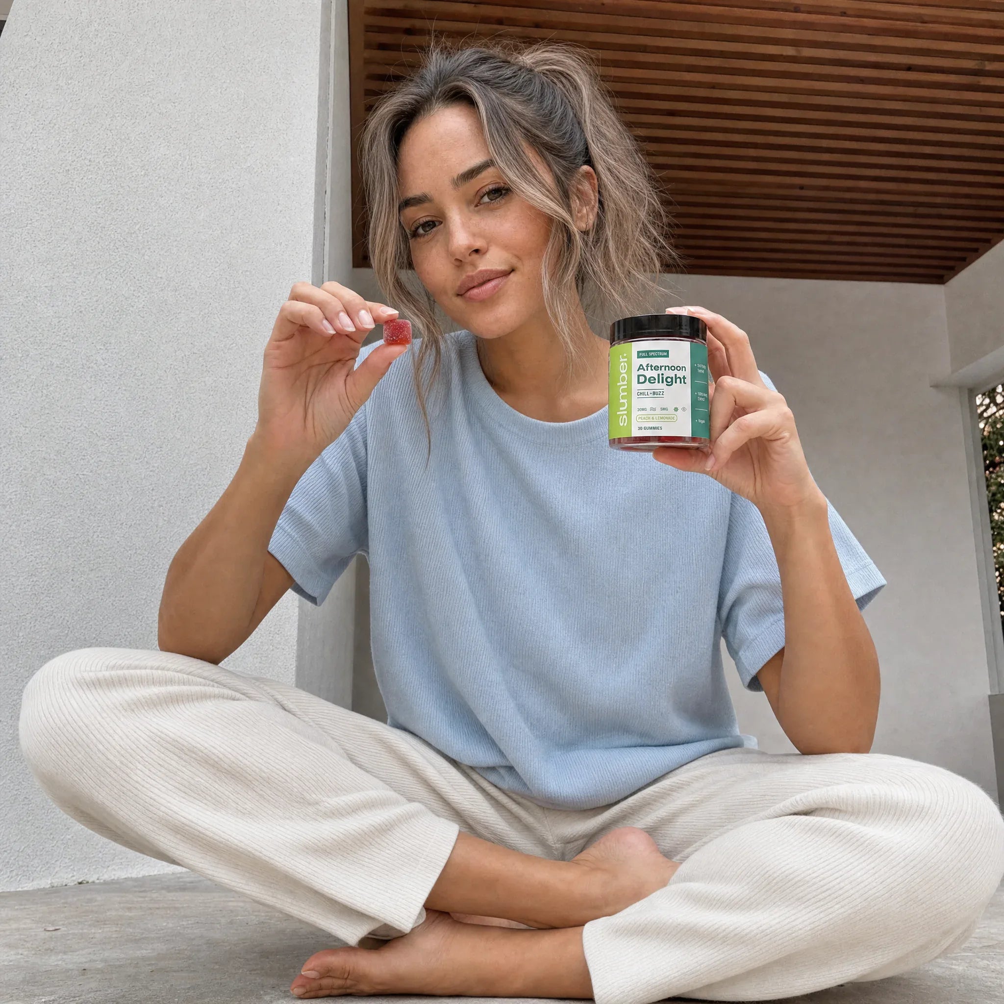Young woman holding a peach gummy